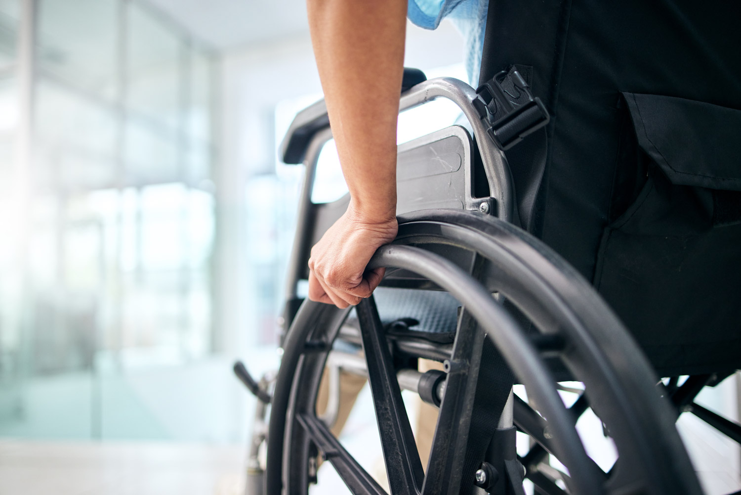 Hand, rehabilitation and person in a wheelchair at a hospital fo